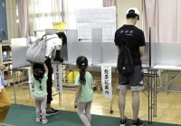 Voters fill out their paper ballots at a polling station in Tokyo on Sunday.