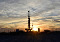 FILE PHOTO: Drilling rigs operate at sunset in Midland