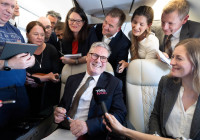 Britain's Prime Minister Sir Keir Starmer talks to journalists as he travels onboard a plane to Washington DC