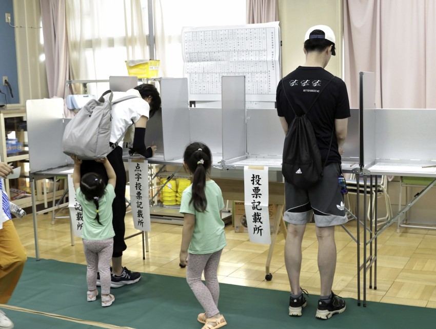 Voters fill out their paper ballots at a polling station in Tokyo on Sunday.